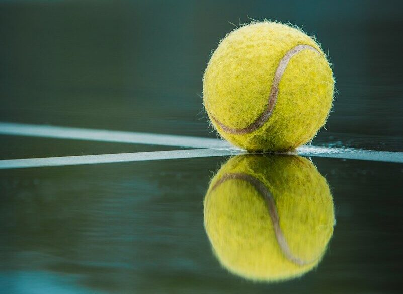 a tennis ball sitting on top of a tennis court